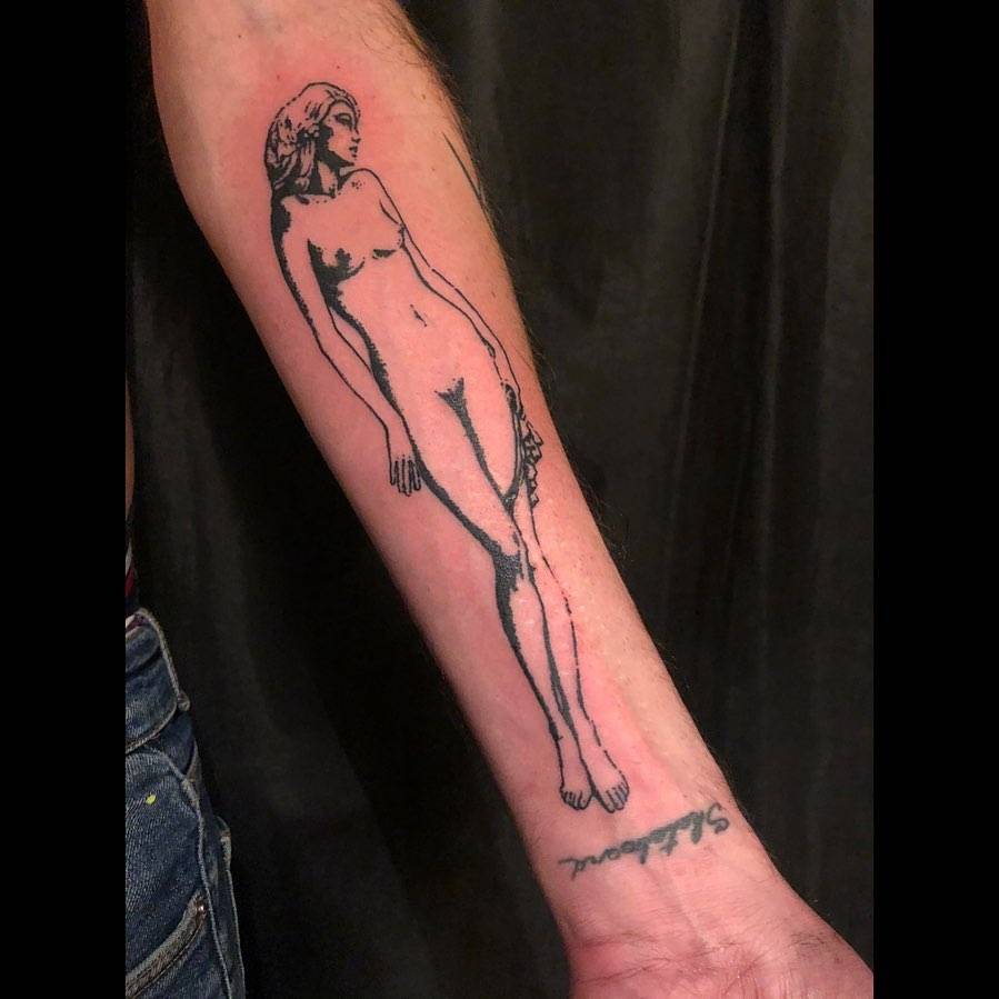 Blackwork style nude woman tattoo located on the inner forearm.