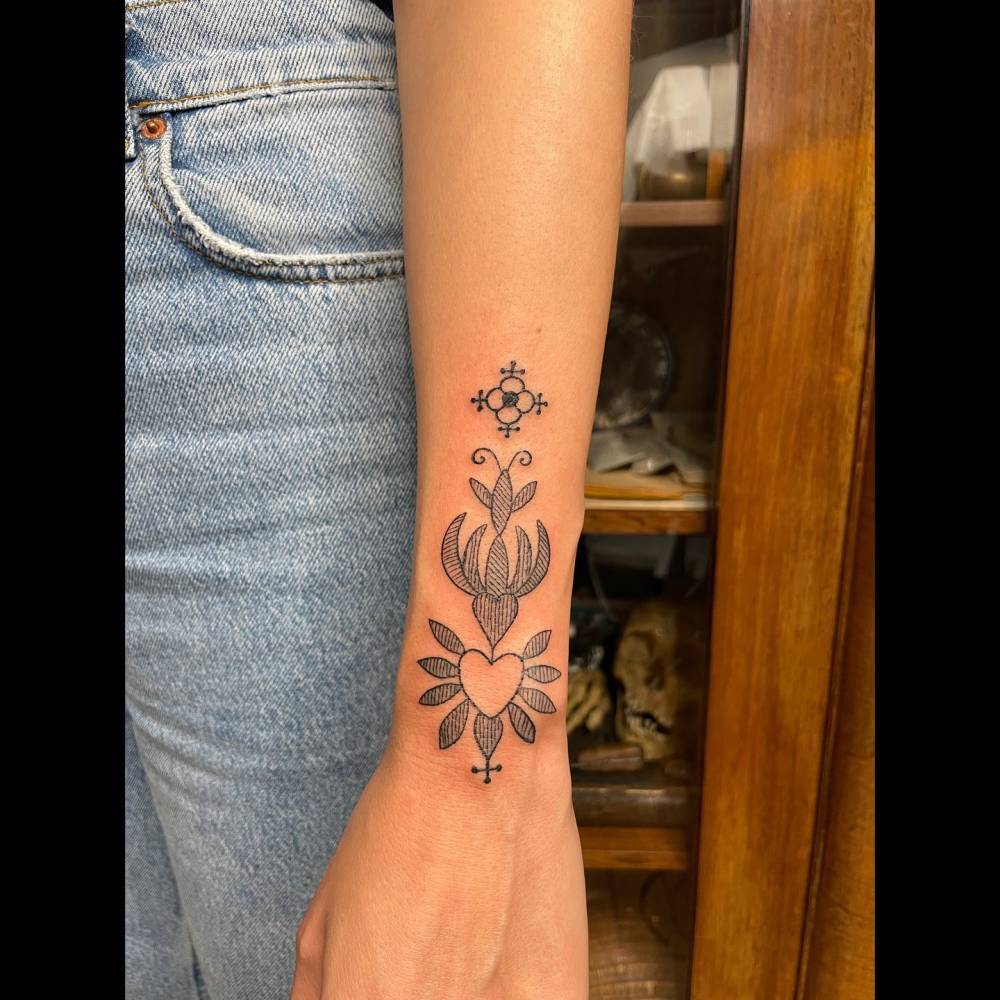 Blackwork style ornamental tattoo located on the wrist.