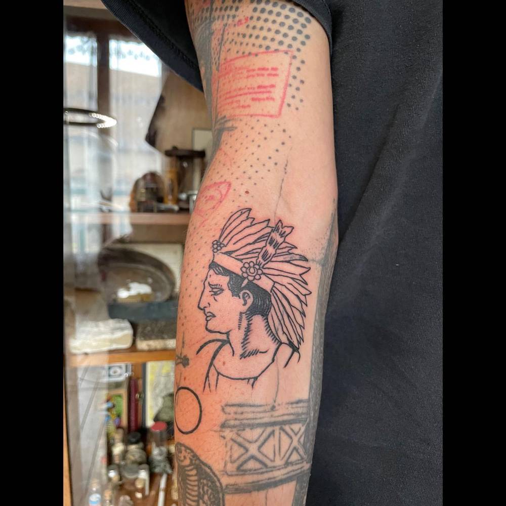 Native american chief portrait tattoo located on the inner forearm.
