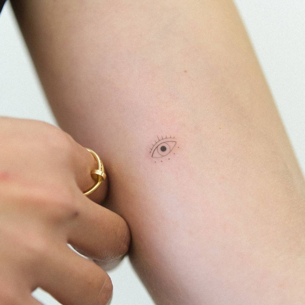 Little evil eye tattoo in minimalistic style placed on the inner forearm.