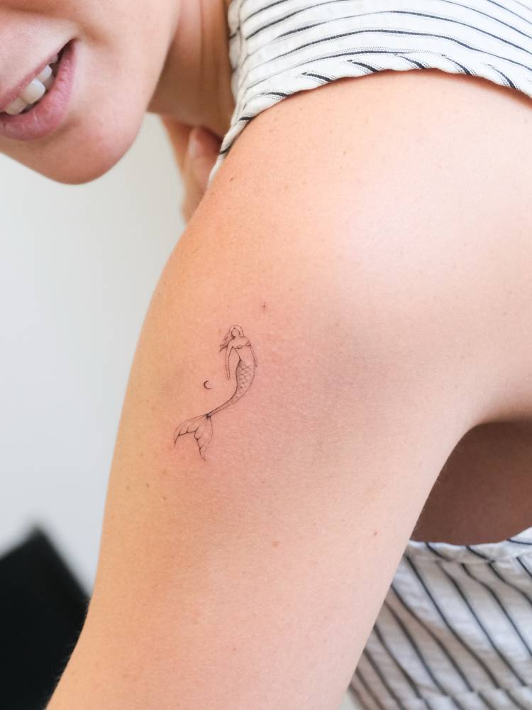 Single needle mermaid tattoo done on the shoulder.