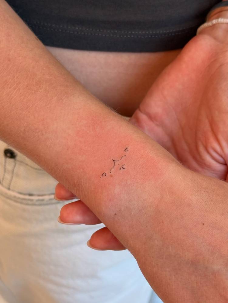 Tiny minimalistic ornamental tattoo done on the wrist.