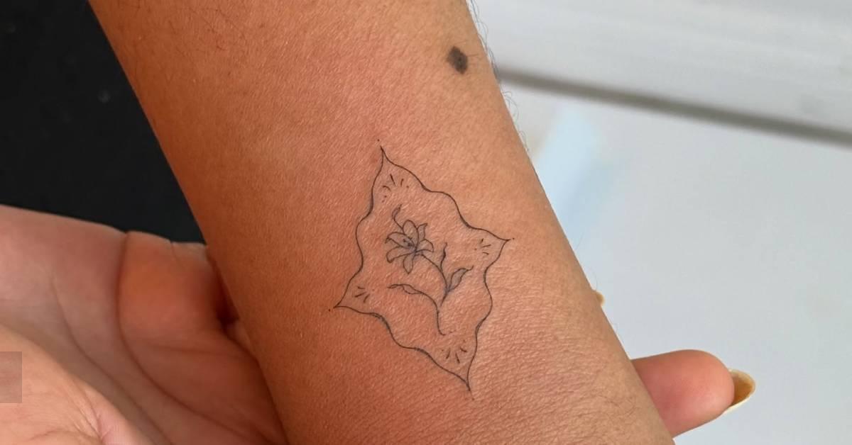 Fine line style ornamental flower tattoo located on the