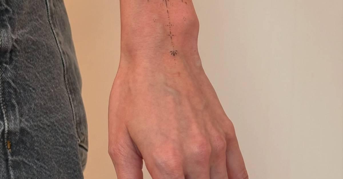 Tiny ornament tattoo in fine line style located on the