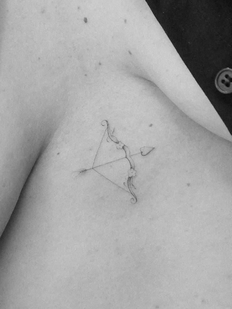 Single needle bow and arrow tattoo located on the sternum.