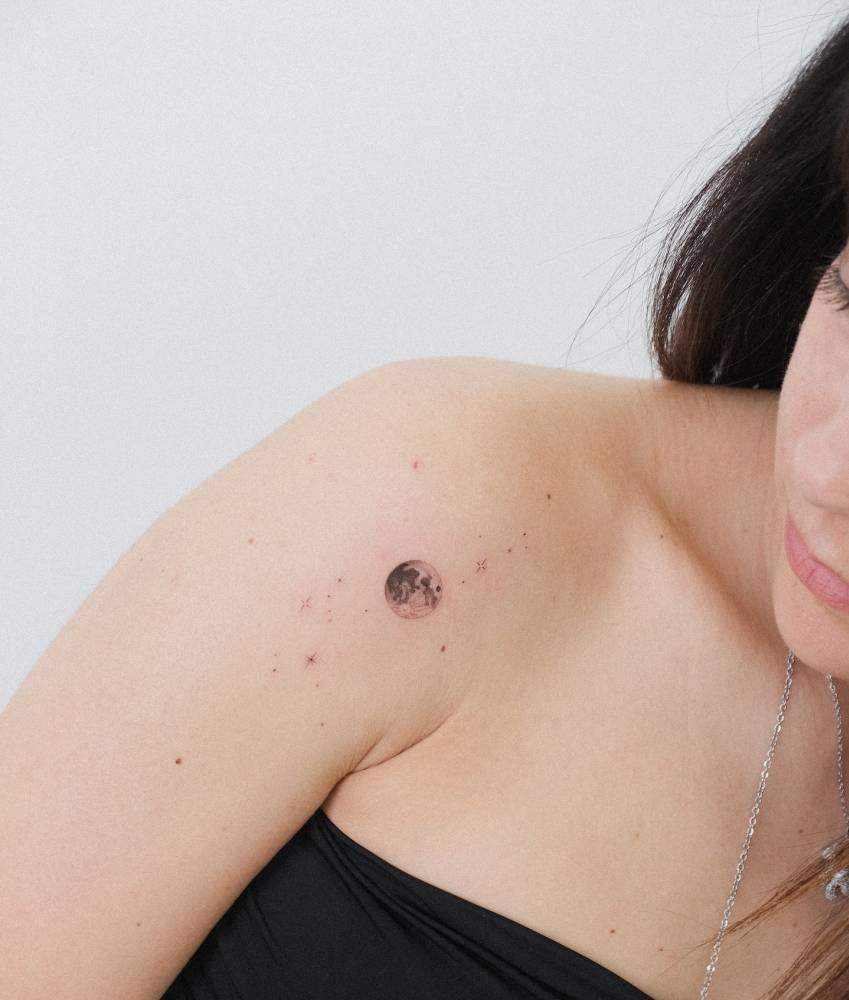 Micro-realistic style full moon tattoo located on the shoulder.