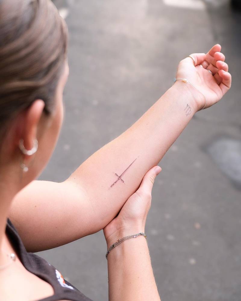 Single needle sword tattoo done on the inner forearm.