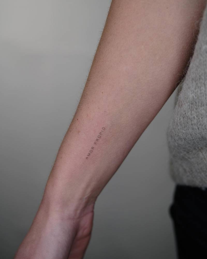Tattoo that says "amor propio" located on the inner forearm.