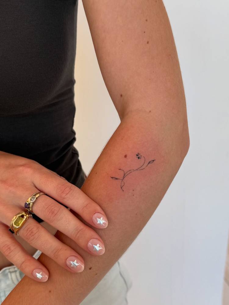 Little minimalistic flower tattoo located on the forearm.