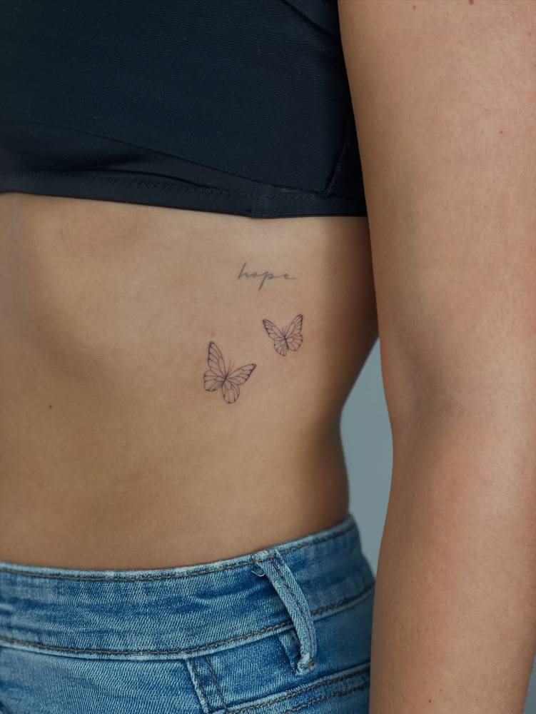 Butterfly couple tattoo done on the rib, fine line style.