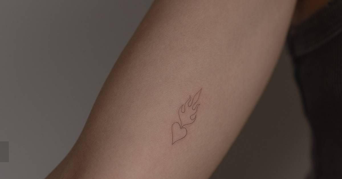 Single needle flaming heart tattoo located on the inner