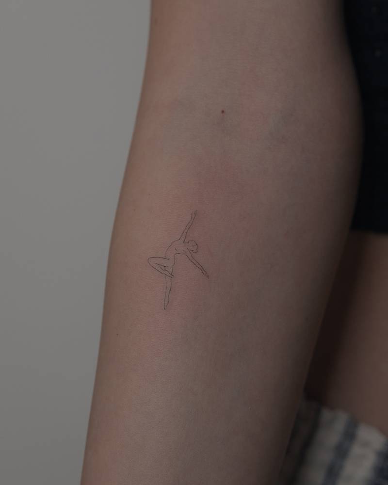 Nude dancer tattoo in fine line style placed on the inner forearm.