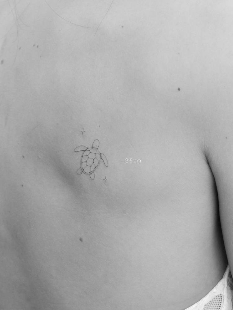 Fine line style turtle tattoo placed on the shoulder blade.