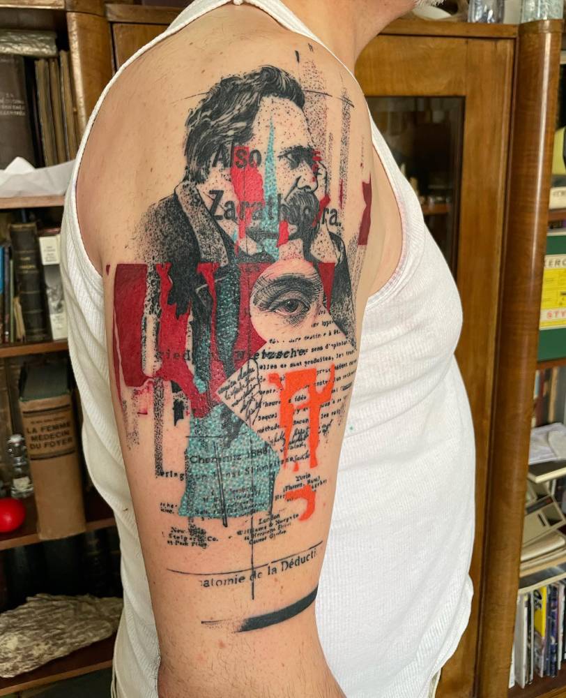 Graphic style Nietzsche tattoo located on the upper arm.