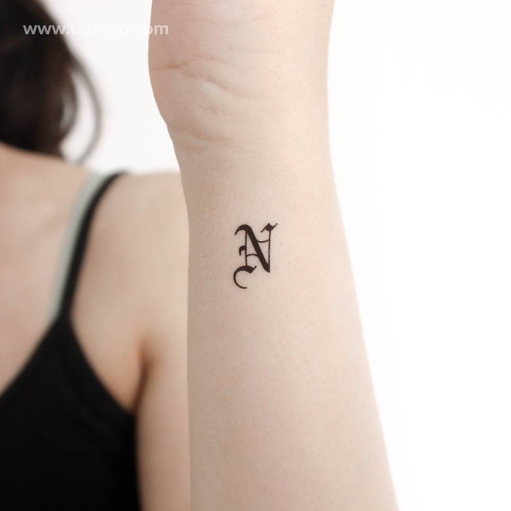 Gothic font "N" letter temporary tattoo located on the wrist.
