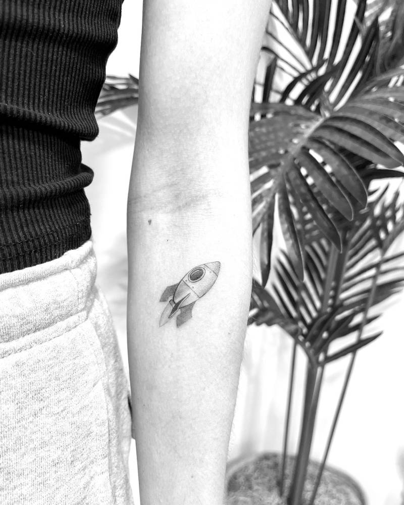 Illustrative style rocket tattoo located on the inner forearm.