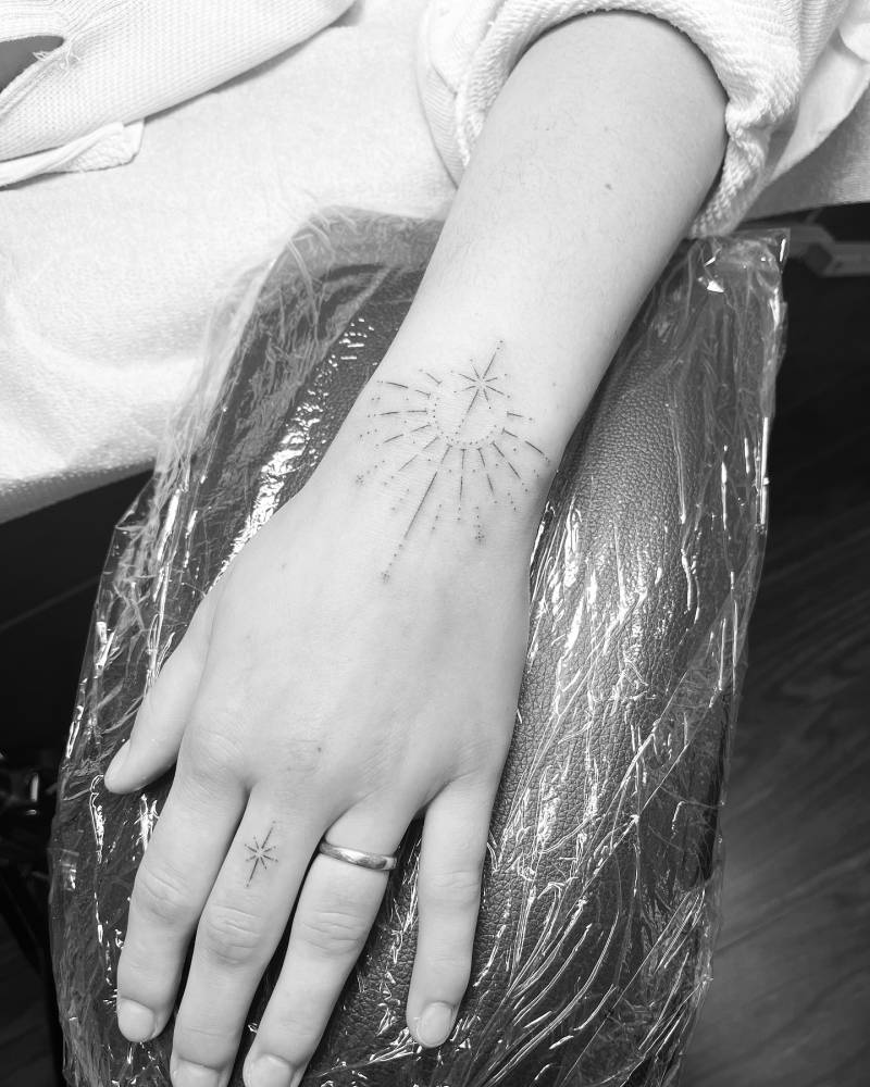 Ornamental tattoo in fine line style located on the wrist.