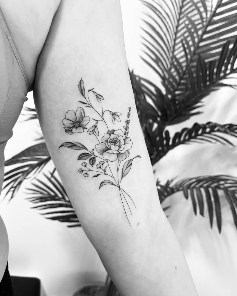 Flower bouquet tattoo in illustrative style located on the inner arm.