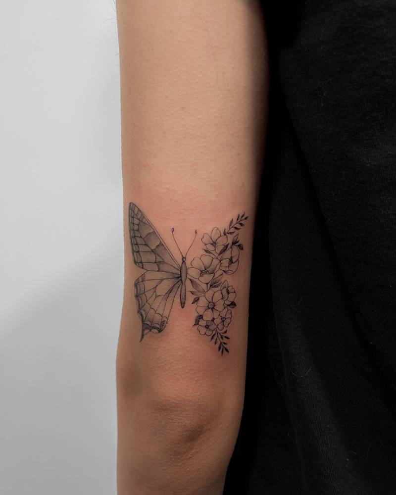 Half butterfly half flower tattoo done on the tricep.