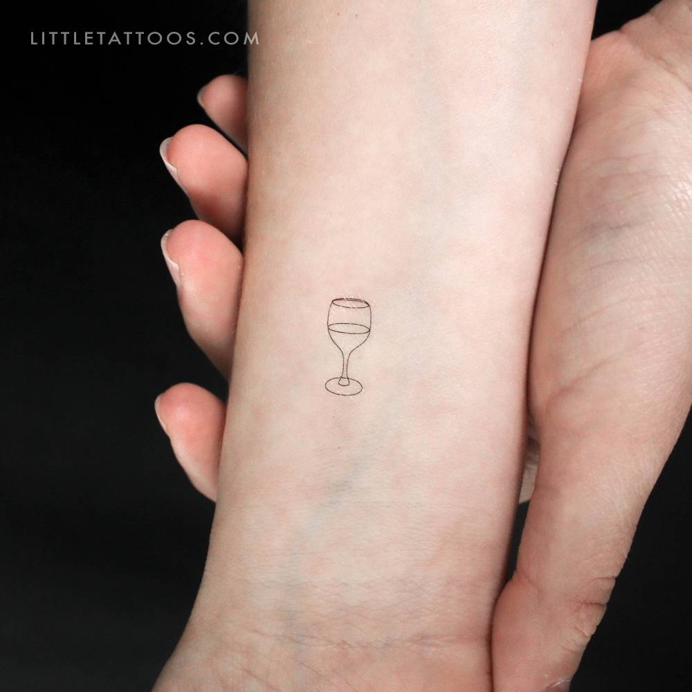 Minimalist fine line wine glass temporary tattoo done on the wrist.