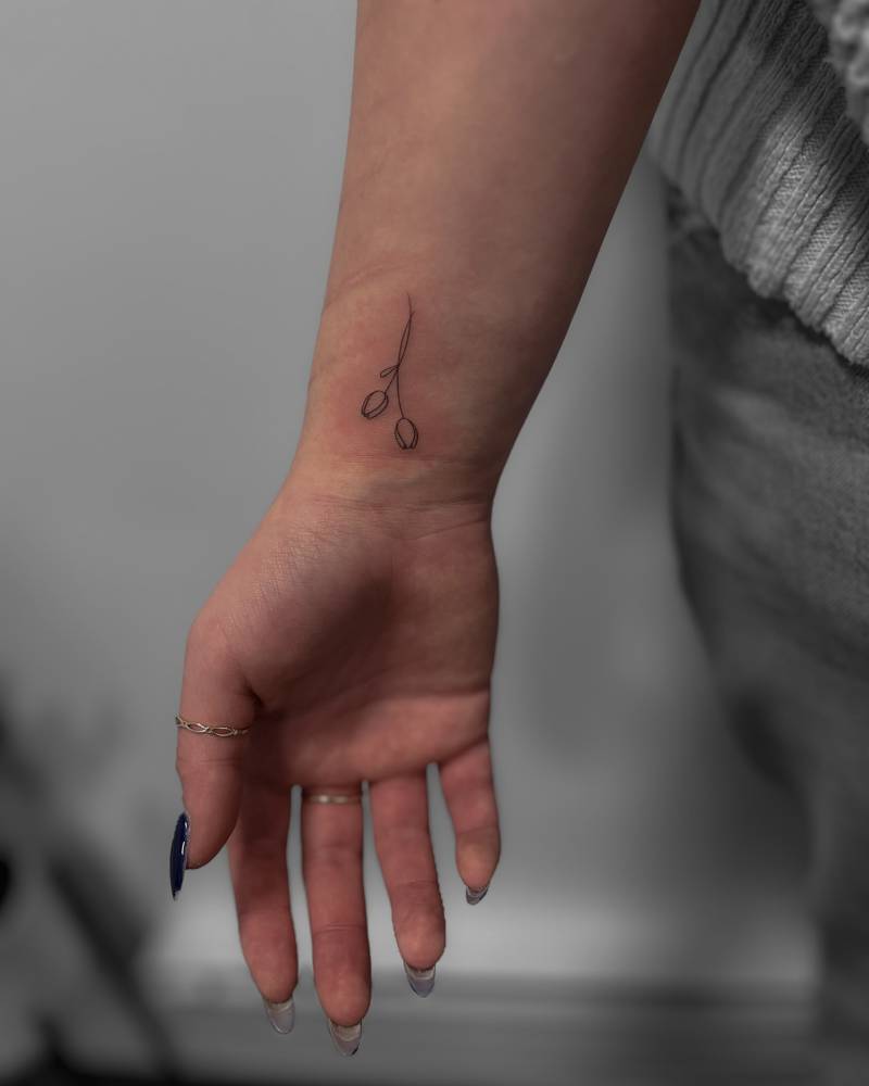 Little fine line tulips tattoo done on the wrist.