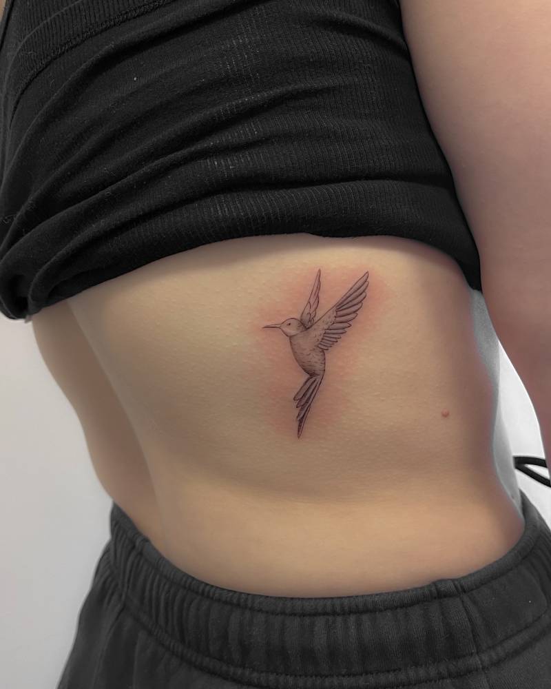 Hummingbird tattoo located on the back, done in illustrative style.