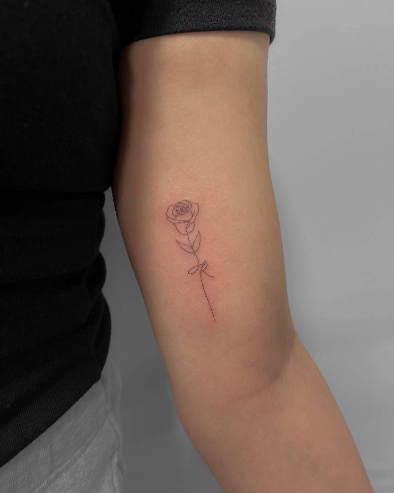 Little rose tattoo placed on the inner arm, done in fine line style.