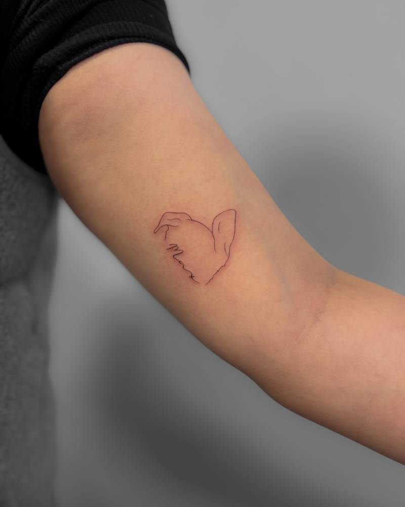 Dog ears and name "Max" tattooed on the inner arm.
