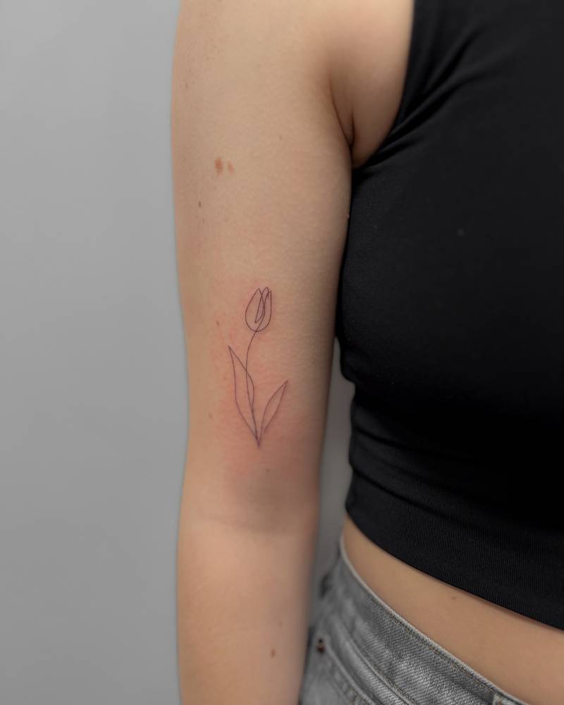 One line tulip flower tattoo done on the bicep.