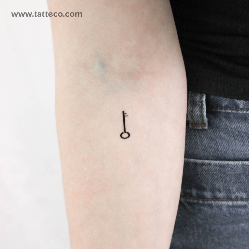 Tiny minimalistic key temporary tattoo located on the inner forearm.