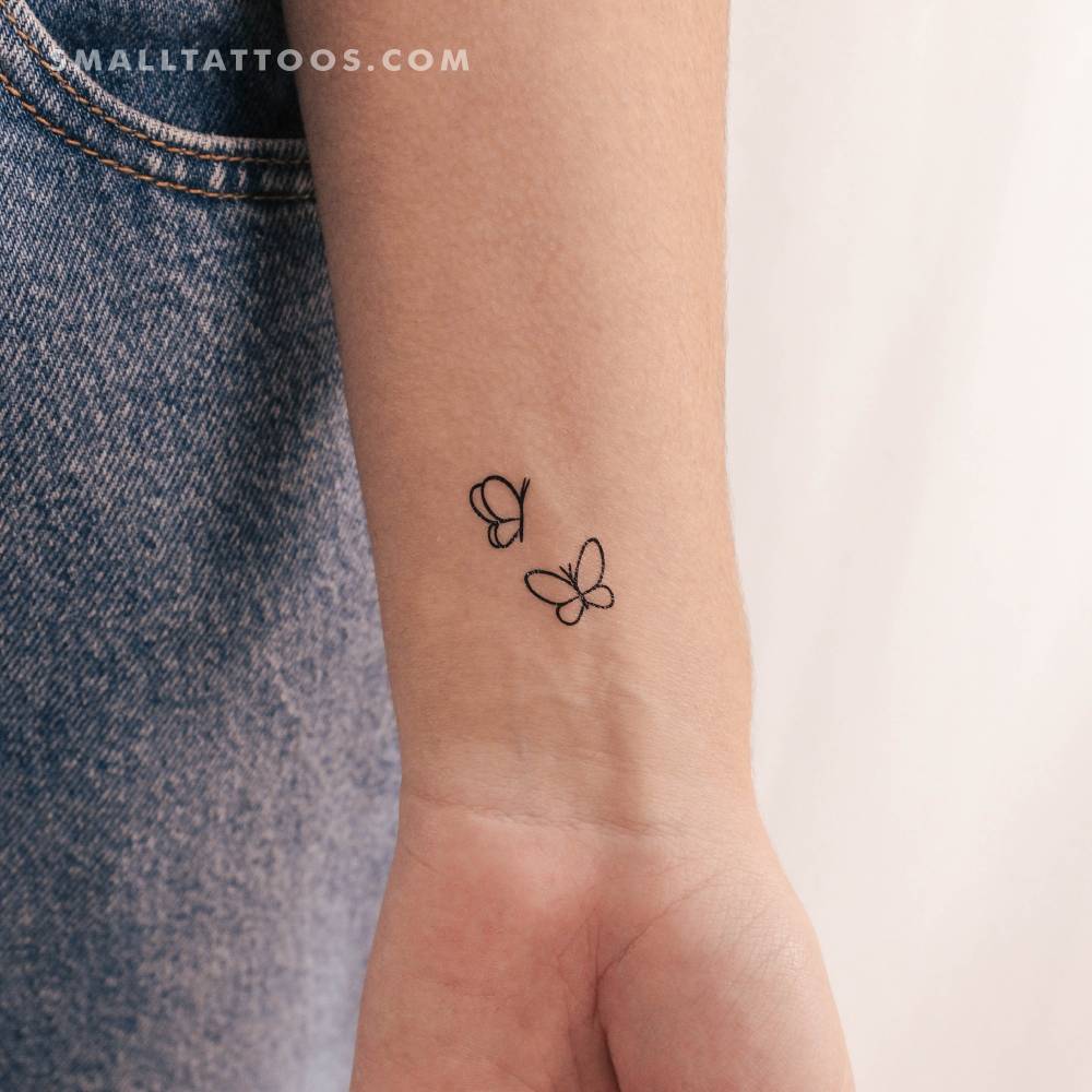 Minimalist style two butterflies temporary tattoo placed on the wrist.