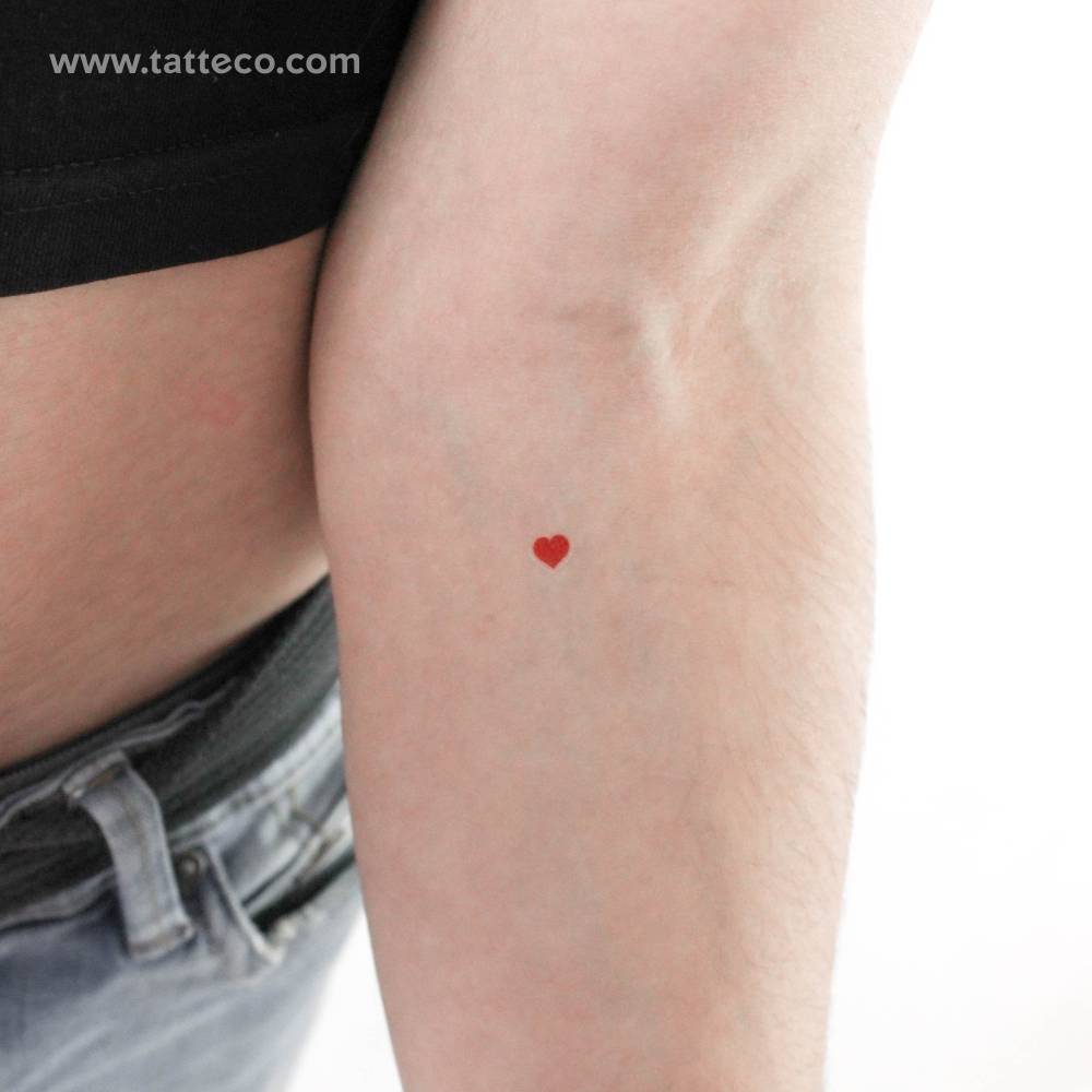 Small minimalistic red heart temporary tattoo located on the inner forearm.