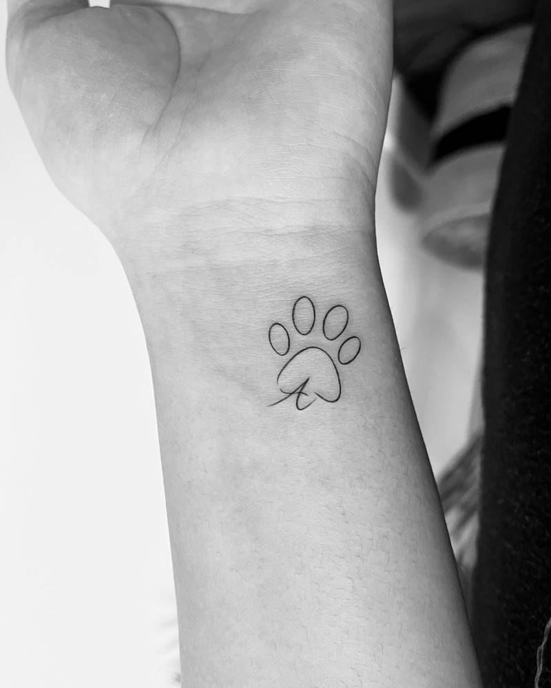 Dog paw print and letter "A" tattoo located on the wrist.