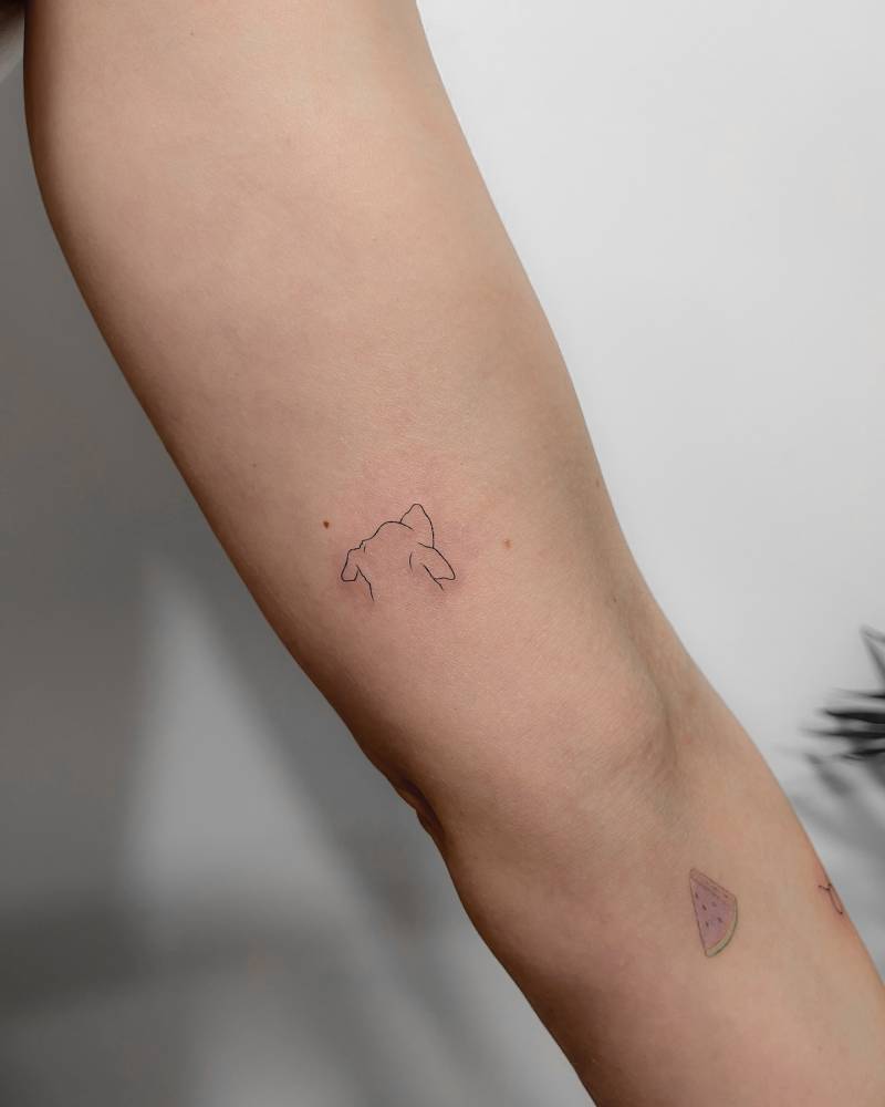 Dog tattoo in minimalistic style located on the inner arm.
