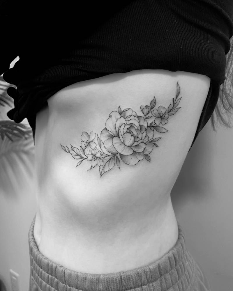 Peony tattoo in illustrative style located on the rib.