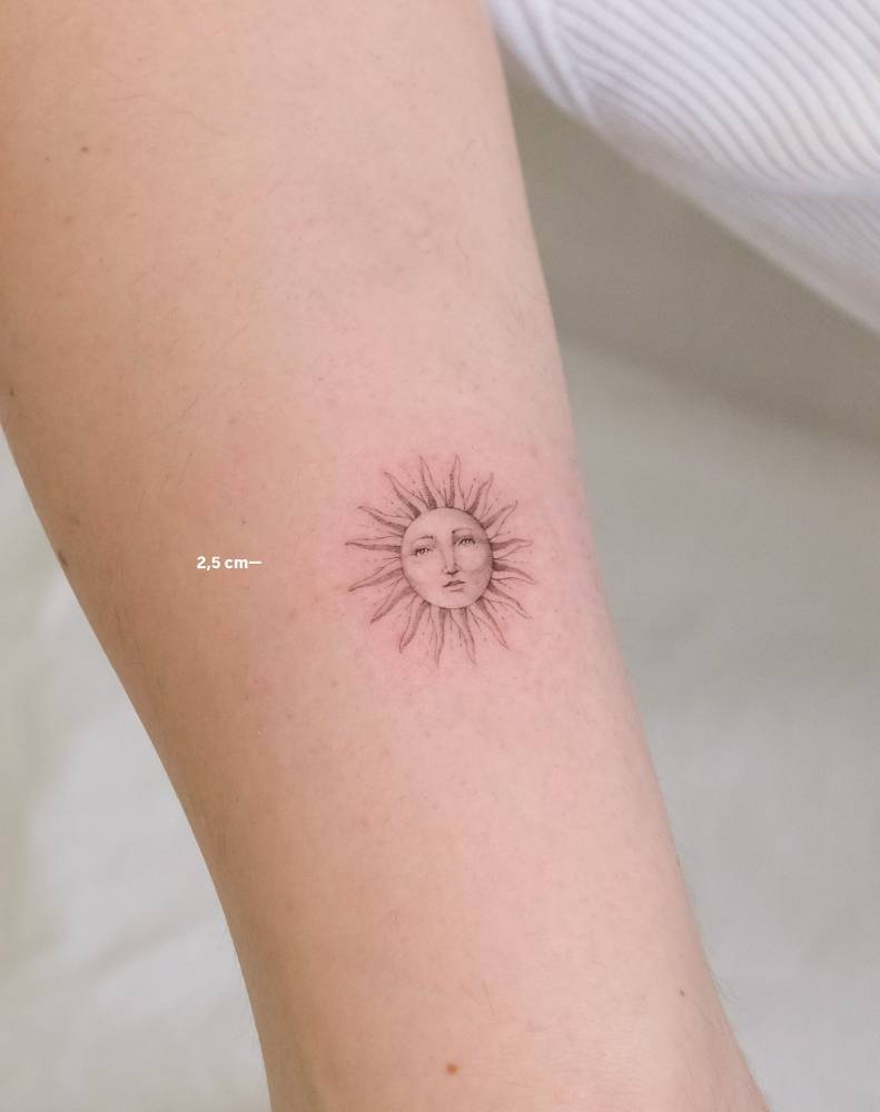Single needle Inti sun tattoo located on the bicep.