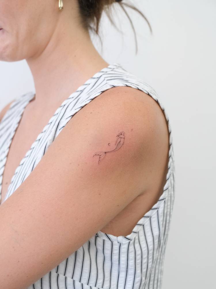 Single needle mermaid tattoo located on the shoulder.