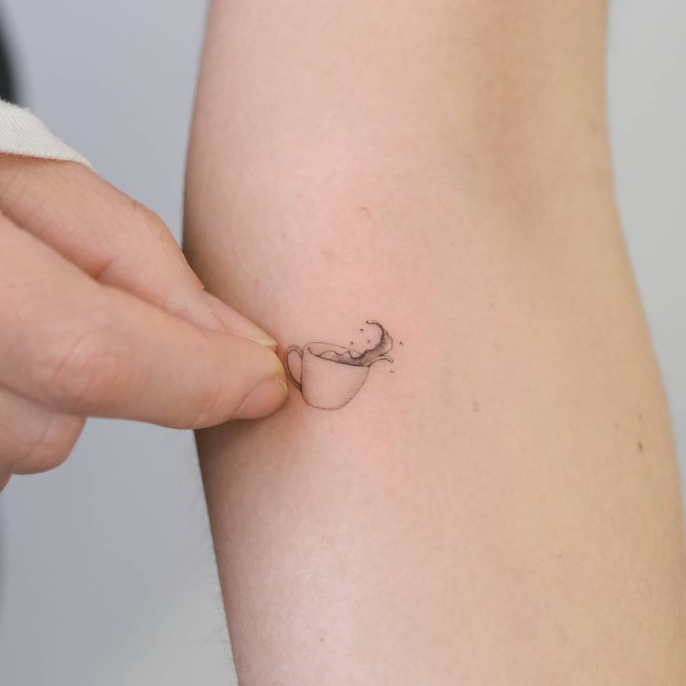 Single needle coffee cup tattoo placed on the inner forearm.