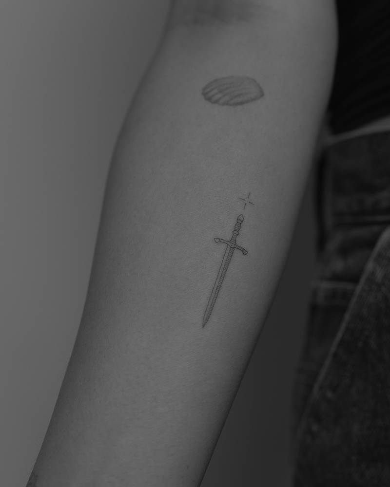 Single needle sword tattoo located on the inner forearm.