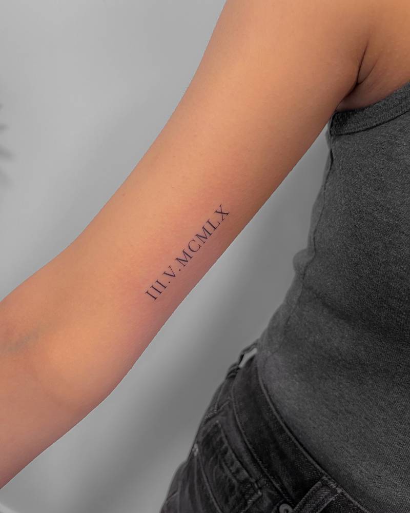Date in roman numerals tattooed on the inner arm.