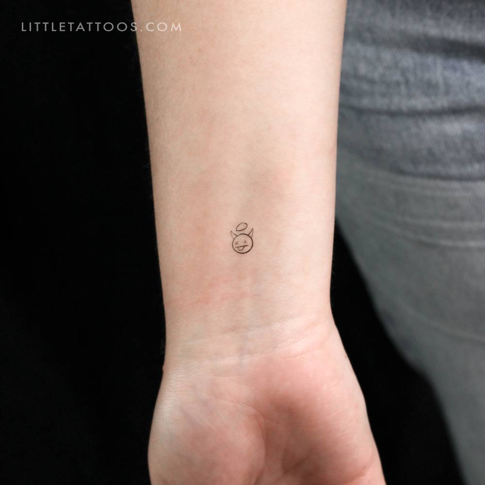 Tiny minimalistic devil temporary tattoo located on the wrist.