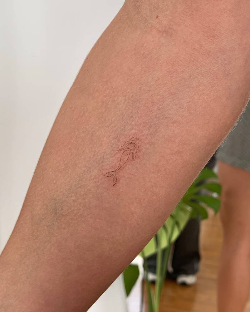 Minimalistic mermaid tattoo located on the inner forearm.