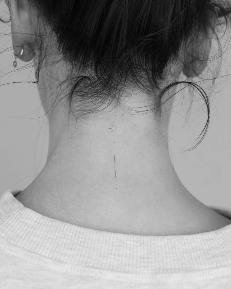 Shooting star tattoo in minimalistic style placed on the back of the neck.