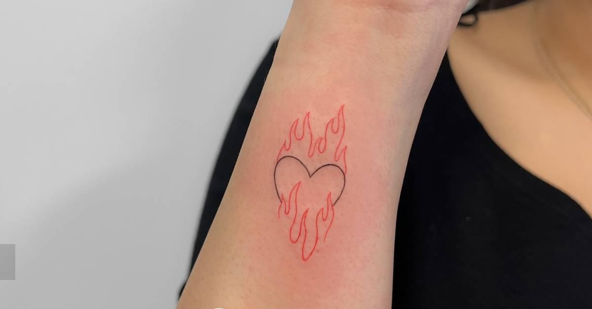 Flaming heart tattoo in fine line style located on the