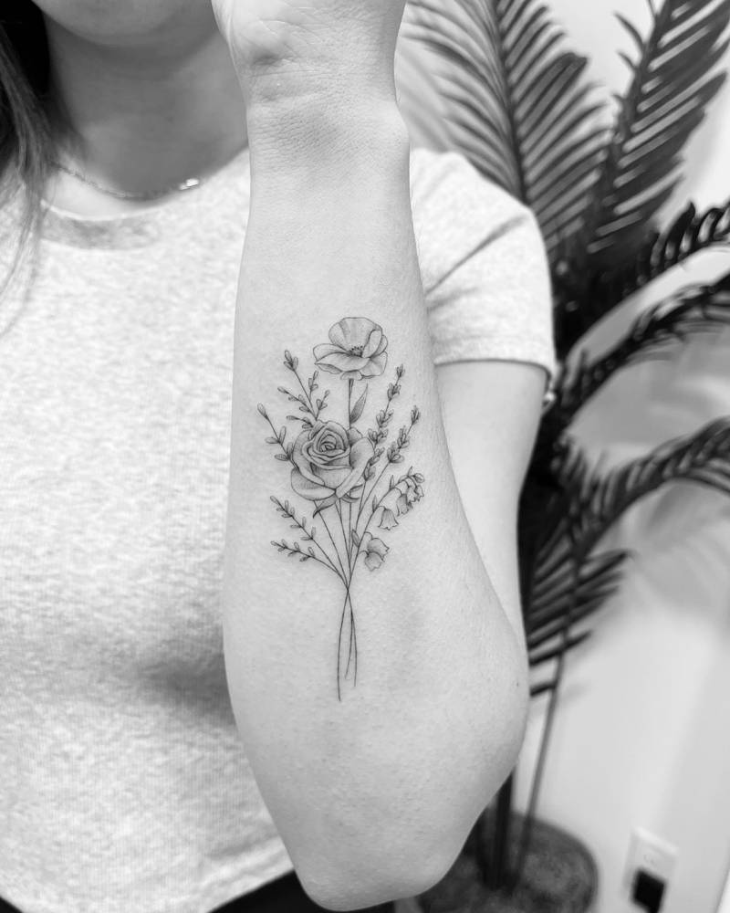 Flower bouquet tattoo in illustrative style located on the forearm.