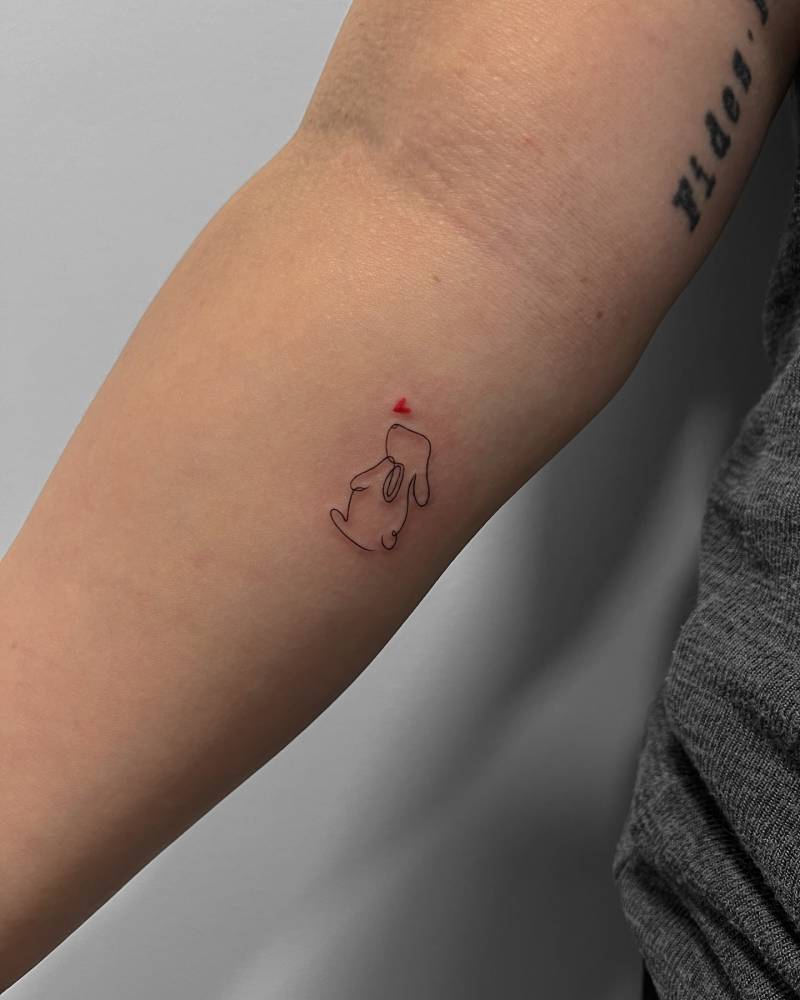 Little bunny tattoo in minimalistic style located on the inner forearm.