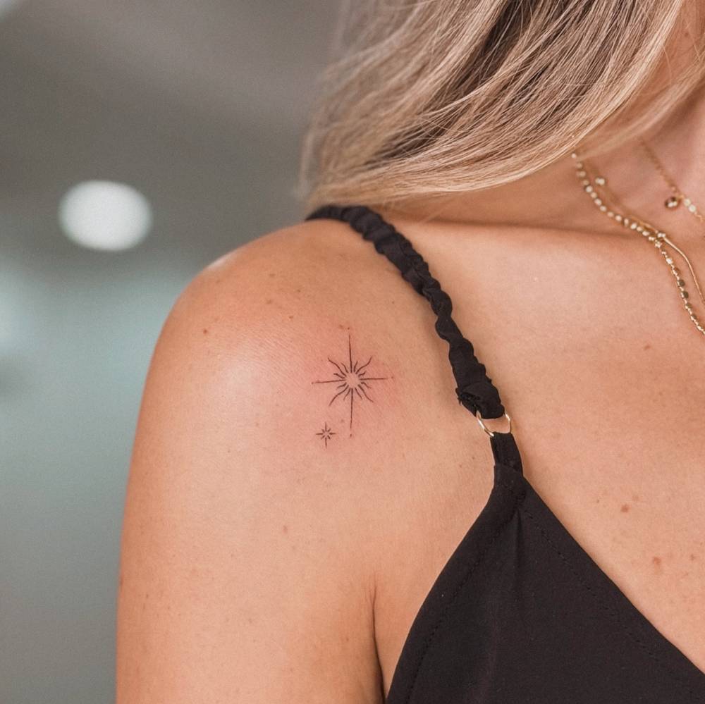 Sparkling stars in fine line style tattooed on the shoulder.
