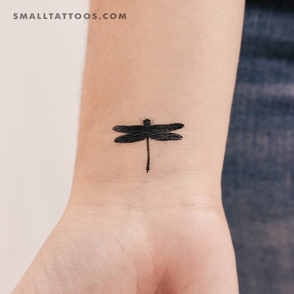 Black dragonfly temporary tattoo located on the wrist.