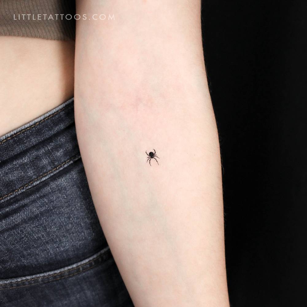 Tiny minimalistic spider temporary tattoo located on the inner forearm.