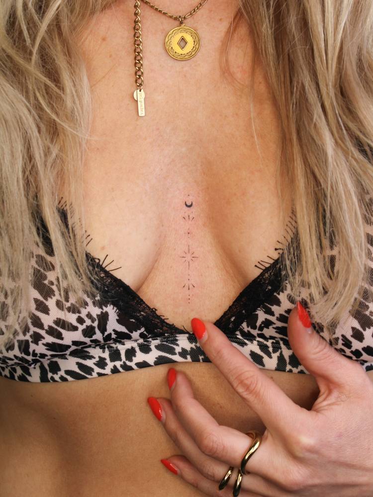 Ornamental north star tattoo located on the sternum, fine line style.